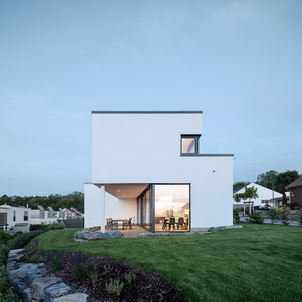 Mittelgroßes, Zweistöckiges Modernes Haus mit Putzfassade, weißer Fassadenfarbe und Flachdach in Sonstige