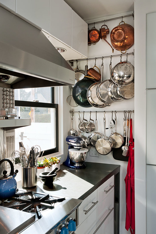 Photo of a contemporary kitchen in Boston with flat-panel cabinets, white cabinets and stainless steel appliances.