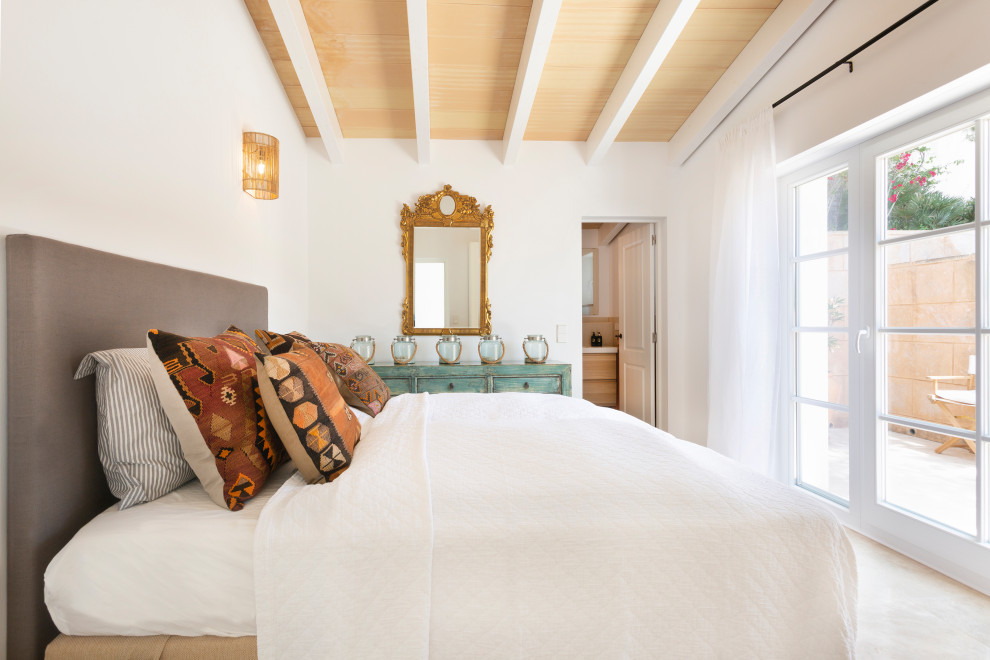 Inspiration for a mid-sized mediterranean master bedroom in Palma de Mallorca with white walls and beige floor.