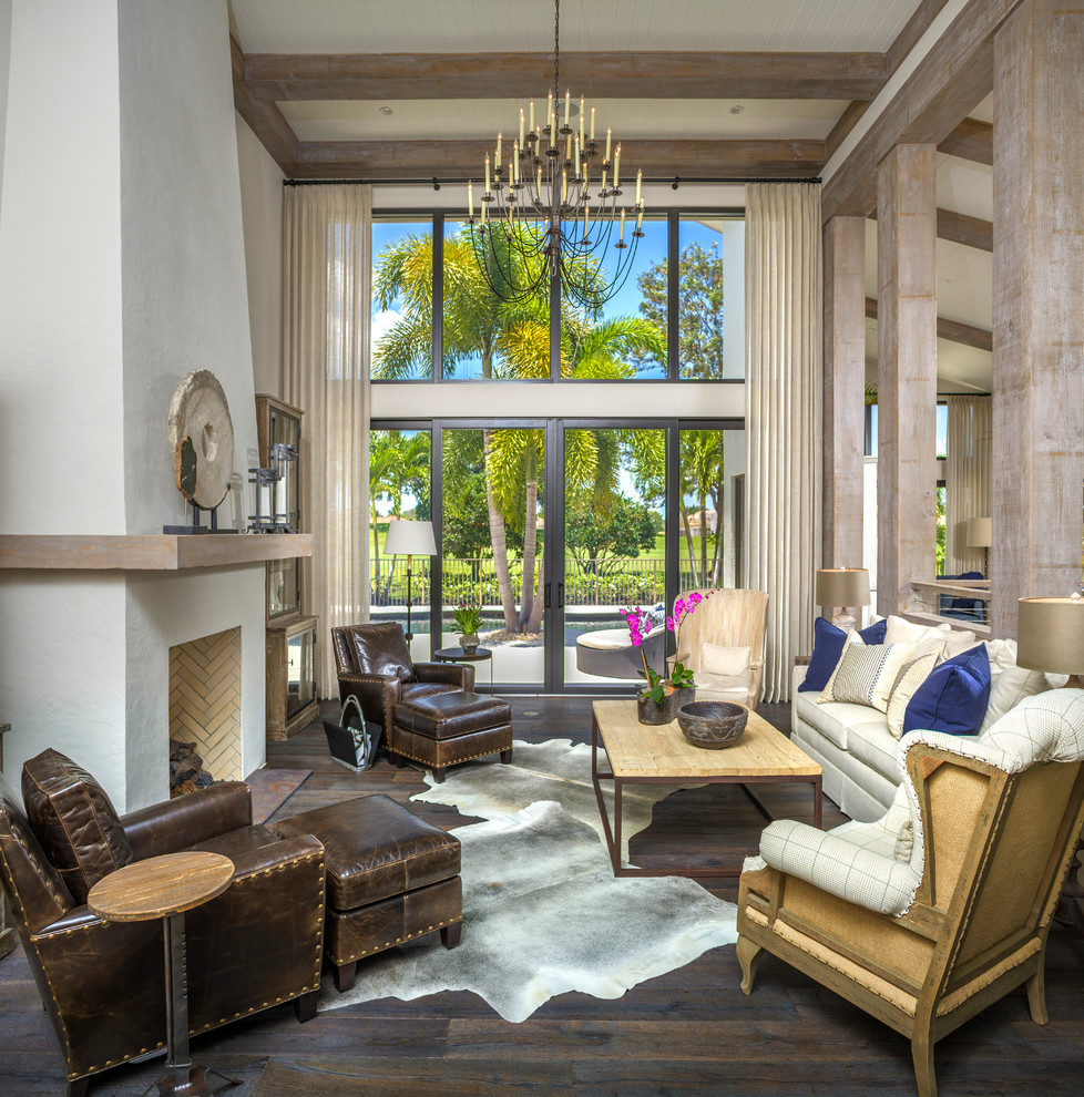 Photo of a tropical living room in Tampa with white walls, dark hardwood floors and a standard fireplace.