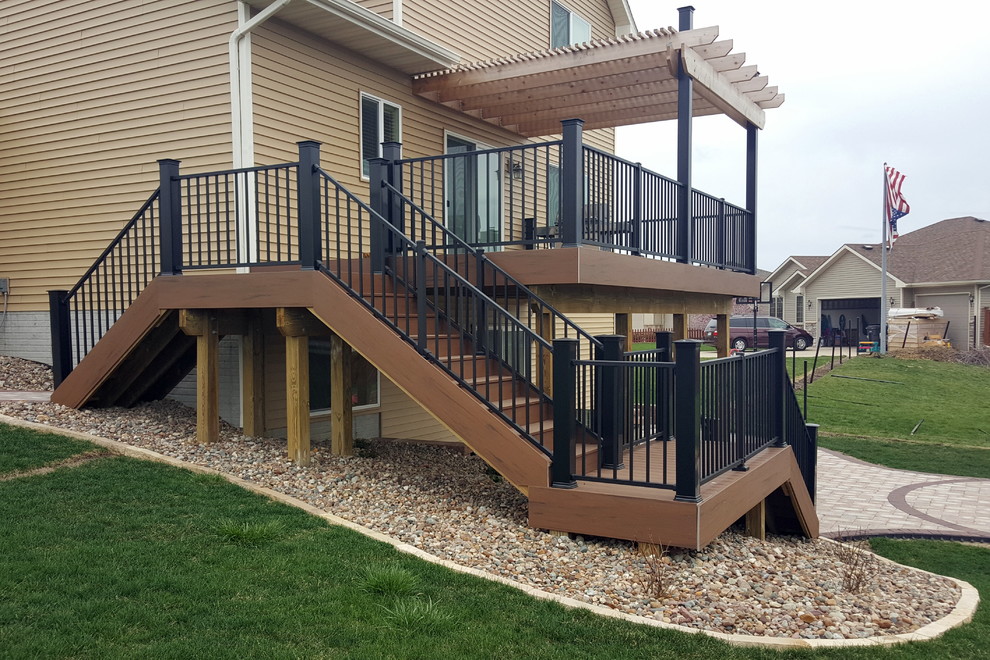 Example of a large backyard deck design with a pergola