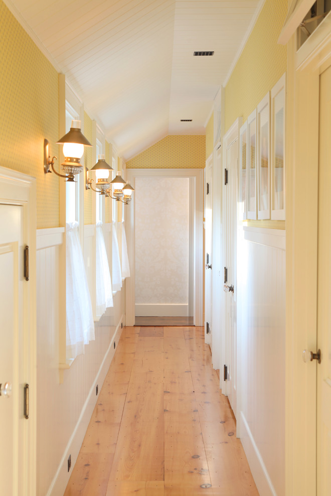 Design ideas for a mid-sized traditional hallway in Boston with yellow walls, light hardwood floors and beige floor.