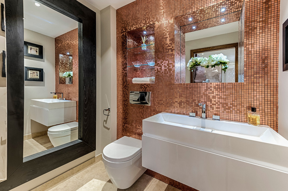 Design ideas for a mid-sized contemporary bathroom in London with open cabinets, a wall-mount toilet, orange tile, mirror tile, beige walls, ceramic floors and a wall-mount sink.