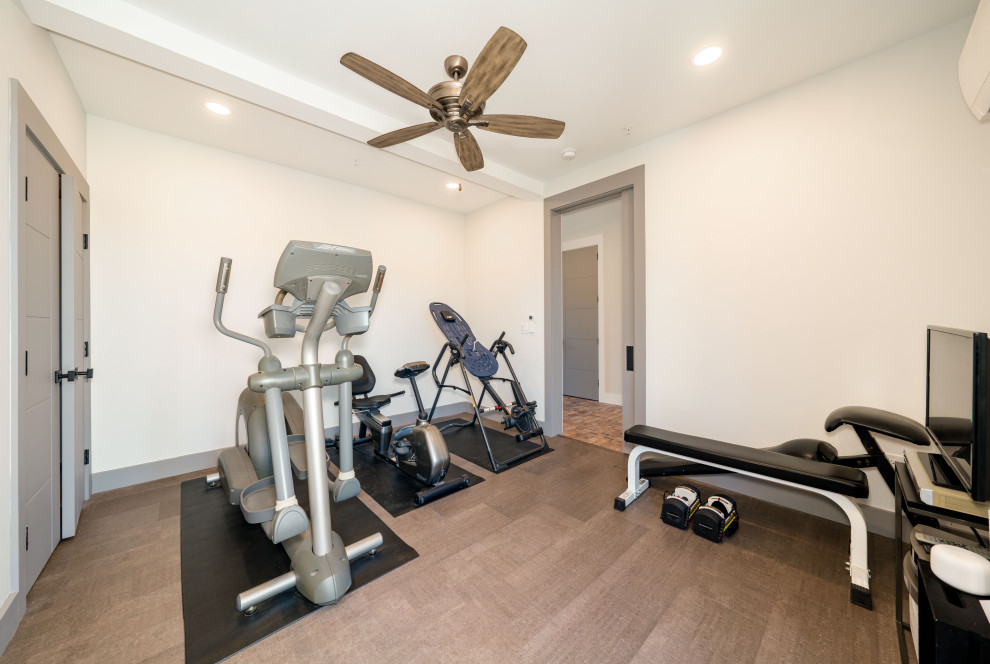 Mid-sized modern home weight room in Boston with beige walls, laminate floors and grey floor.