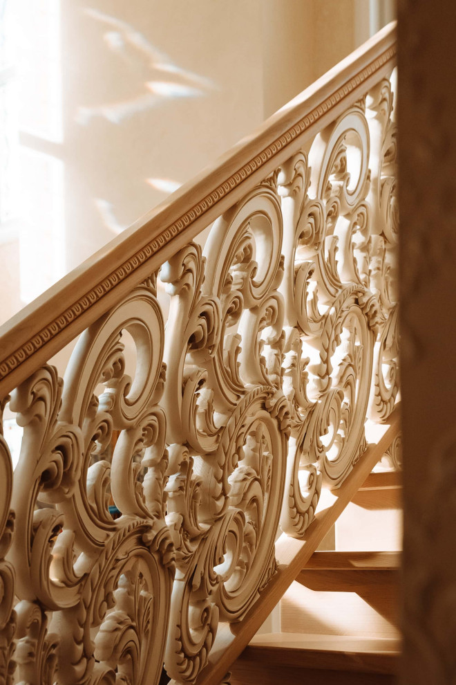 Cette image montre un grand escalier traditionnel en U avec des marches en bois, des contremarches en bois, un garde-corps en bois, du papier peint et rangements.