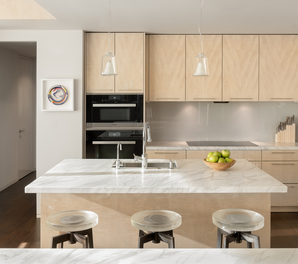 Photo of a mid-sized modern u-shaped open plan kitchen in San Francisco with an undermount sink, flat-panel cabinets, light wood cabinets, marble benchtops, beige splashback, glass sheet splashback, black appliances, dark hardwood floors and with island.