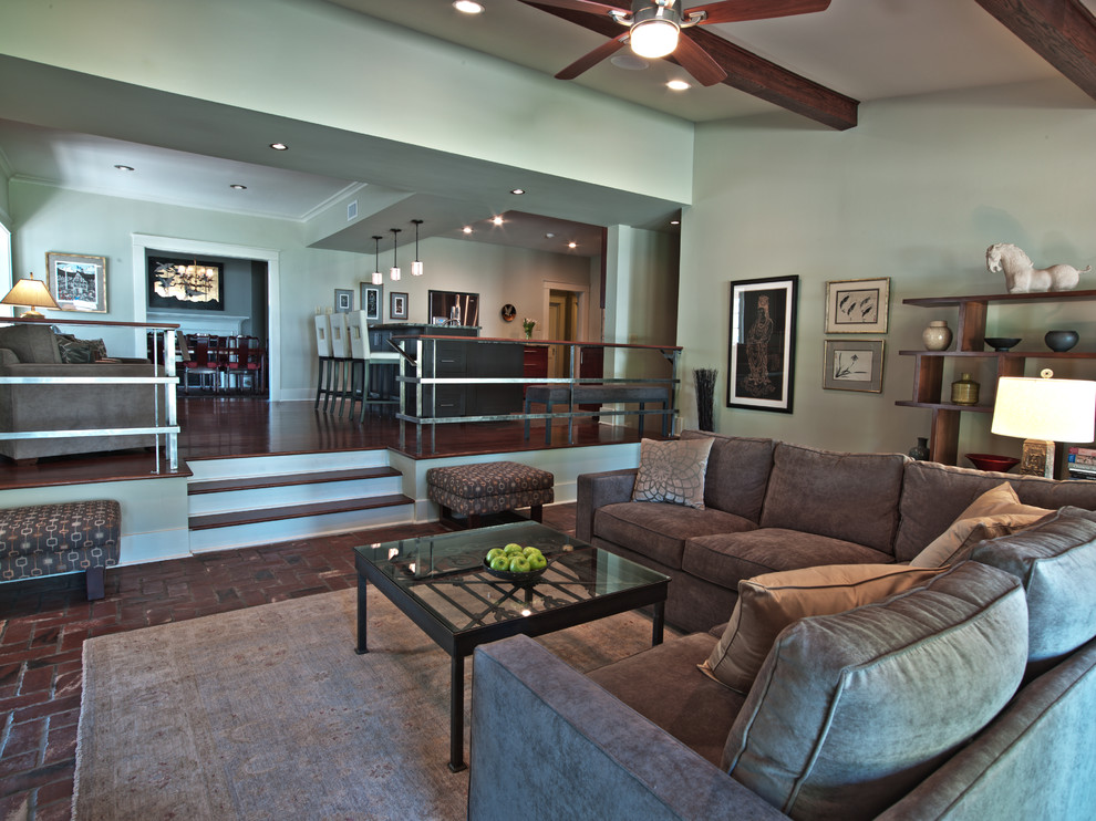Photo of a large contemporary formal enclosed living room in Atlanta with brick floors, a standard fireplace, a wood fireplace surround, a wall-mounted tv, grey walls and red floor.