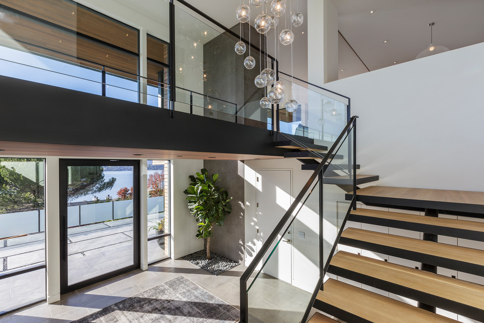 Large modern foyer in San Francisco with concrete floors and a metal front door.