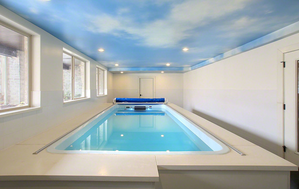 Inspiration for a large traditional indoor rectangular lap pool in Chicago with a water feature and concrete pavers.
