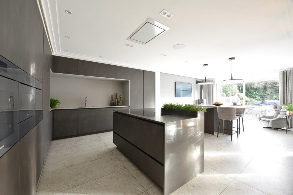 Design ideas for a large contemporary l-shaped open plan kitchen in Manchester with an undermount sink, flat-panel cabinets, grey cabinets, quartzite benchtops, beige splashback, limestone splashback, coloured appliances, porcelain floors, with island, grey floor, grey benchtop and coffered.