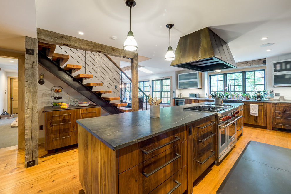 Inspiration for a mid-sized country galley separate kitchen in Philadelphia with open cabinets, medium wood cabinets, soapstone benchtops, white splashback, stainless steel appliances, medium hardwood floors, with island and brown floor.