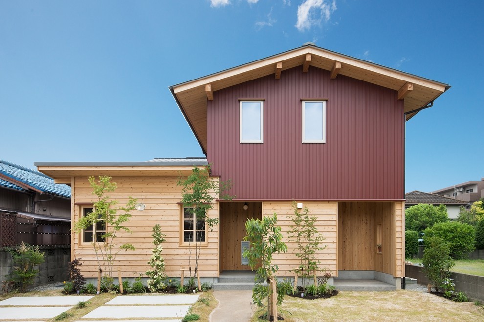Inspiration for a contemporary two-storey red exterior in Other with mixed siding and a gable roof.