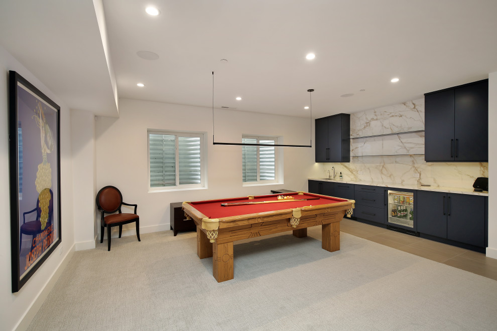 Photo of a large modern fully buried basement in Chicago with a game room, white walls, carpet and grey floor.