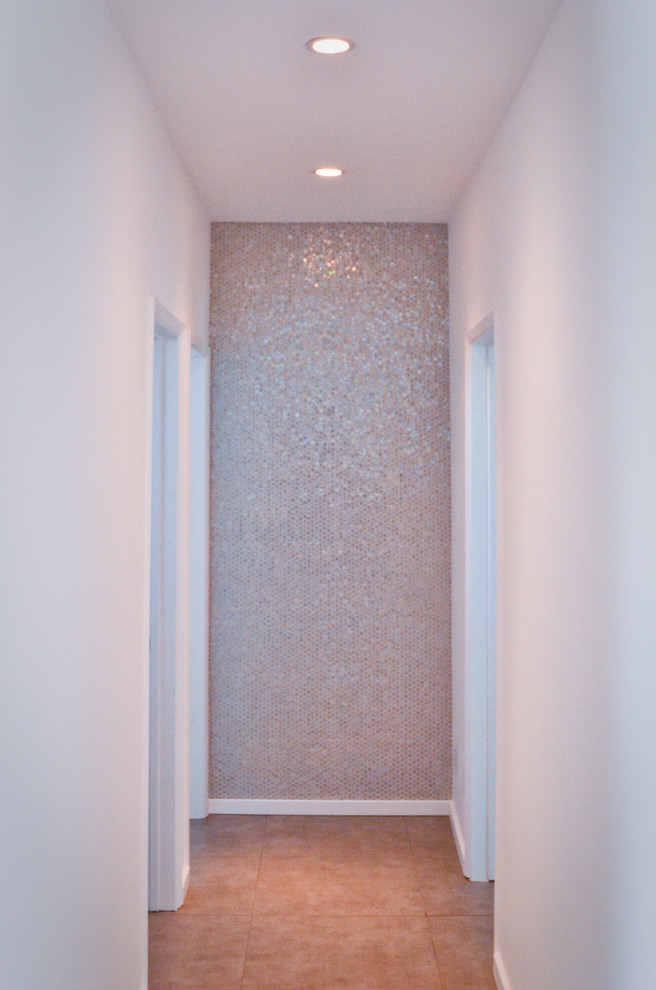 This is an example of a mid-sized midcentury hallway in Los Angeles with white walls and porcelain floors.