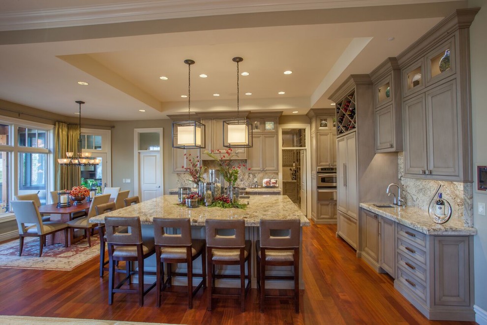 Inspiration for a large transitional medium tone wood floor open concept kitchen remodel with recessed-panel cabinets, gray cabinets, granite countertops, beige backsplash, paneled appliances and an island