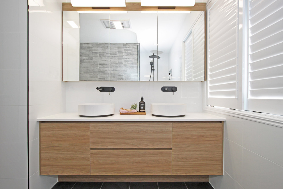 Inspiration for a mid-sized modern kids bathroom in Brisbane with shaker cabinets, light wood cabinets, a freestanding tub, an alcove shower, a two-piece toilet, white tile, ceramic tile, white walls, porcelain floors, a vessel sink, engineered quartz benchtops, grey floor, an open shower and white benchtops.