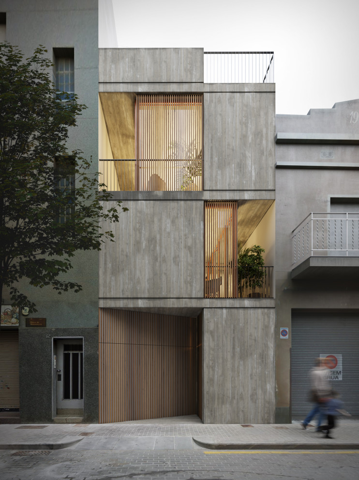 Mid-sized industrial three-storey concrete grey house exterior in Barcelona with a flat roof and a green roof.