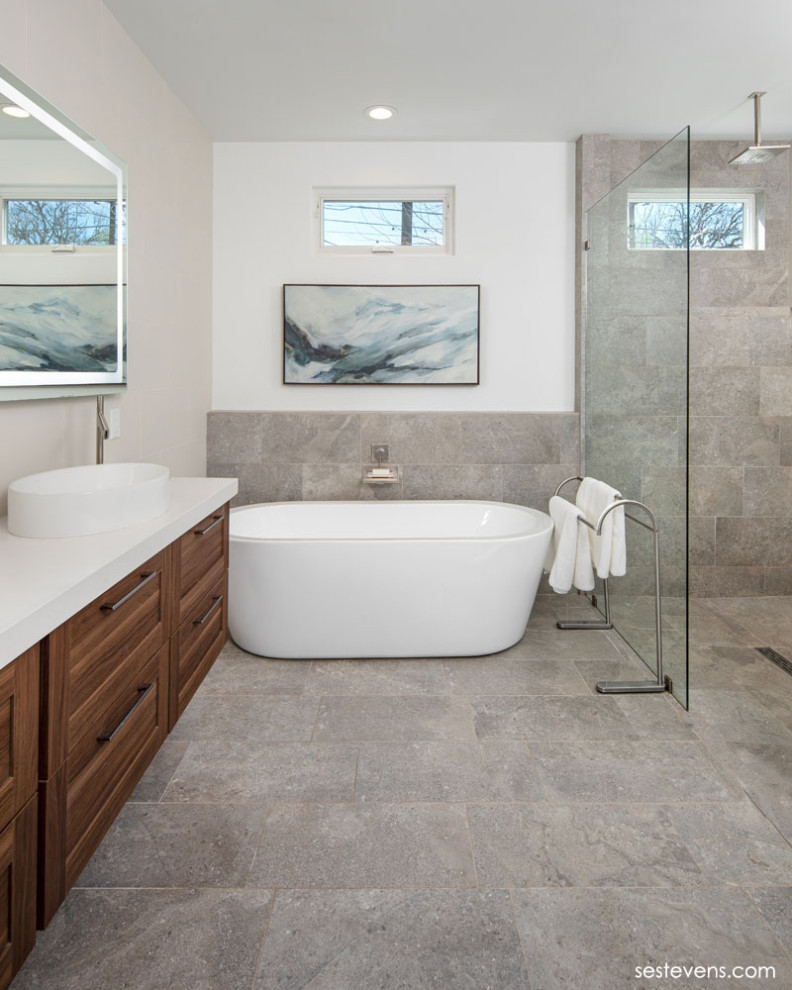 Bild på ett mellanstort funkis en-suite badrum, med luckor med upphöjd panel, skåp i mellenmörkt trä, en öppen dusch, vit kakel, vita väggar, ett piedestal handfat, brunt golv, med dusch som är öppen och ett fristående badkar