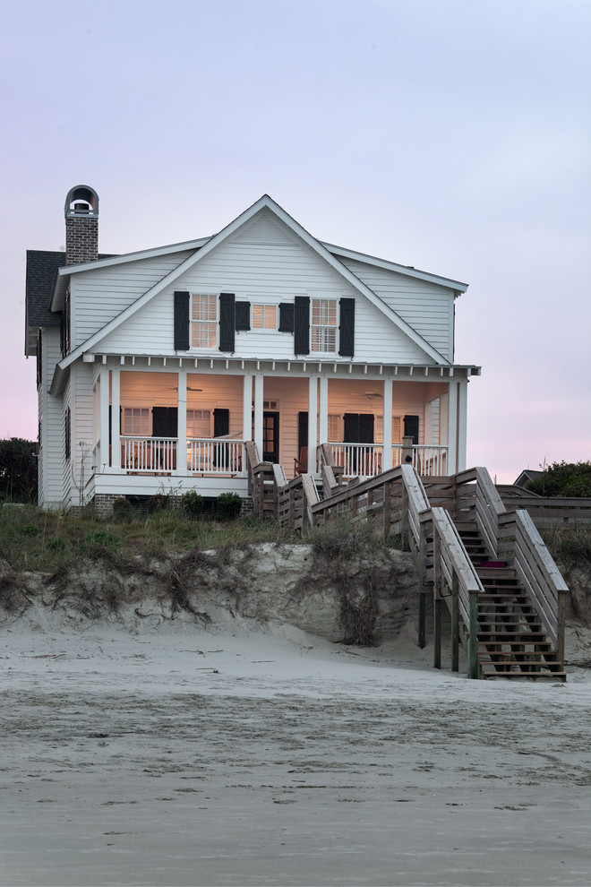 Photo of a large beach style two-storey white exterior in Charleston with a gable roof.