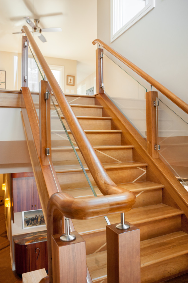 This is an example of a large contemporary wood u-shaped staircase in Detroit with wood risers and wood railing.