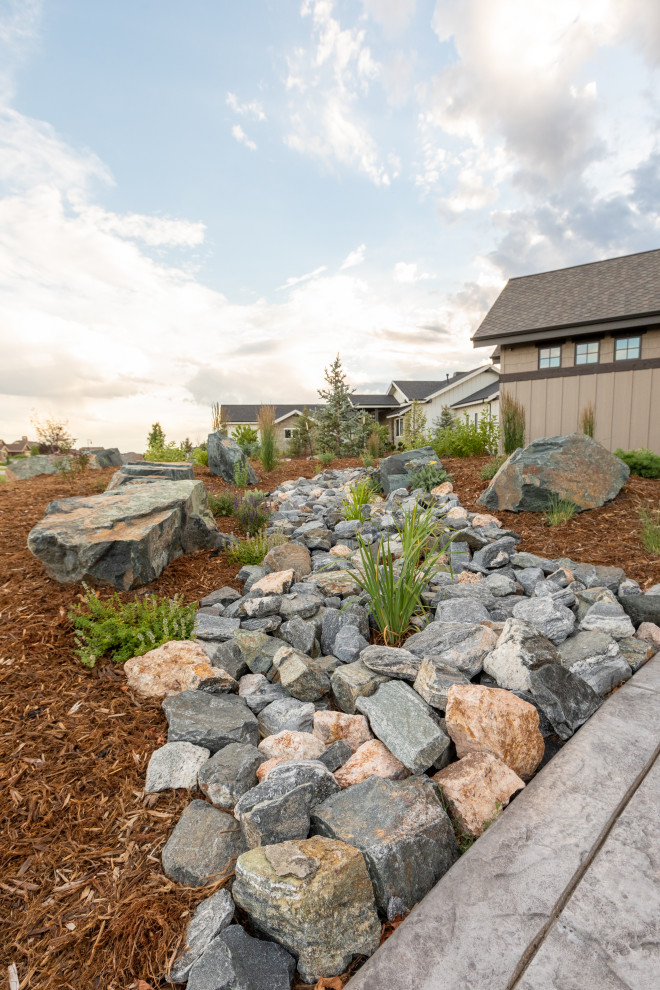 Expansive arts and crafts front yard full sun garden in Denver with with rock feature and mulch.