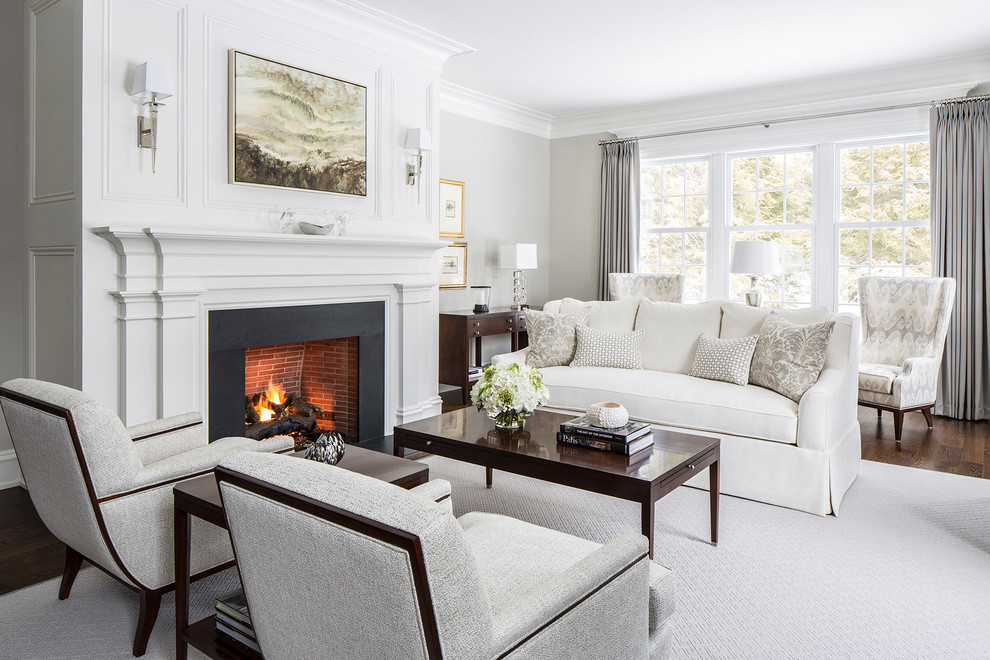 Photo of a large transitional formal open concept living room in New York with grey walls, dark hardwood floors, a standard fireplace, a plaster fireplace surround, no tv and brown floor.