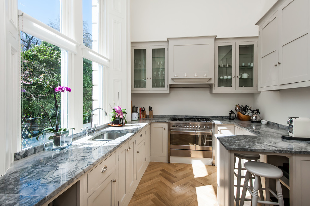 Inspiration for a mid-sized traditional u-shaped kitchen in Surrey with an undermount sink, shaker cabinets, grey cabinets, granite benchtops, grey splashback, stainless steel appliances, medium hardwood floors and a peninsula.