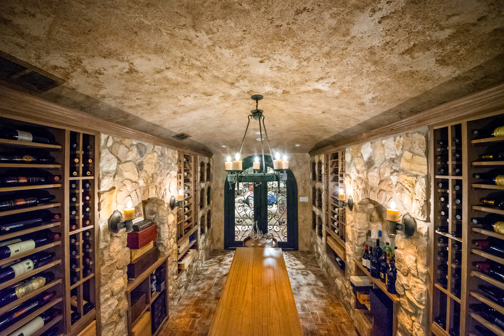 Photo of a large country wine cellar in New York with porcelain floors, display racks and grey floor.