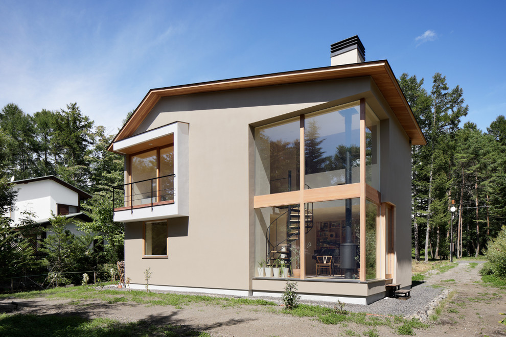 Design ideas for a scandinavian two-storey brown exterior in Other with a gable roof.