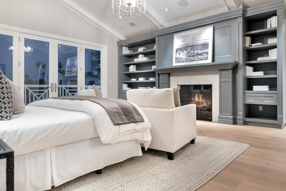 Inspiration for a large transitional master bedroom in Los Angeles with grey walls, light hardwood floors, a standard fireplace and a tile fireplace surround.