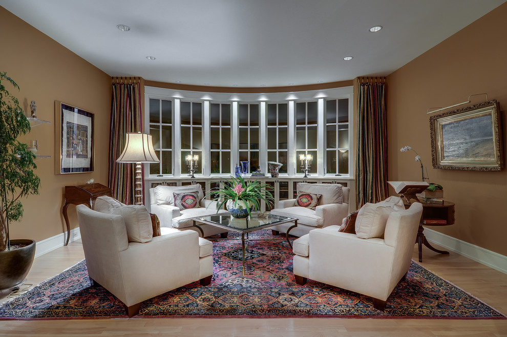 This is an example of a large traditional formal open concept living room in Atlanta with brown walls, light hardwood floors, no fireplace and no tv.
