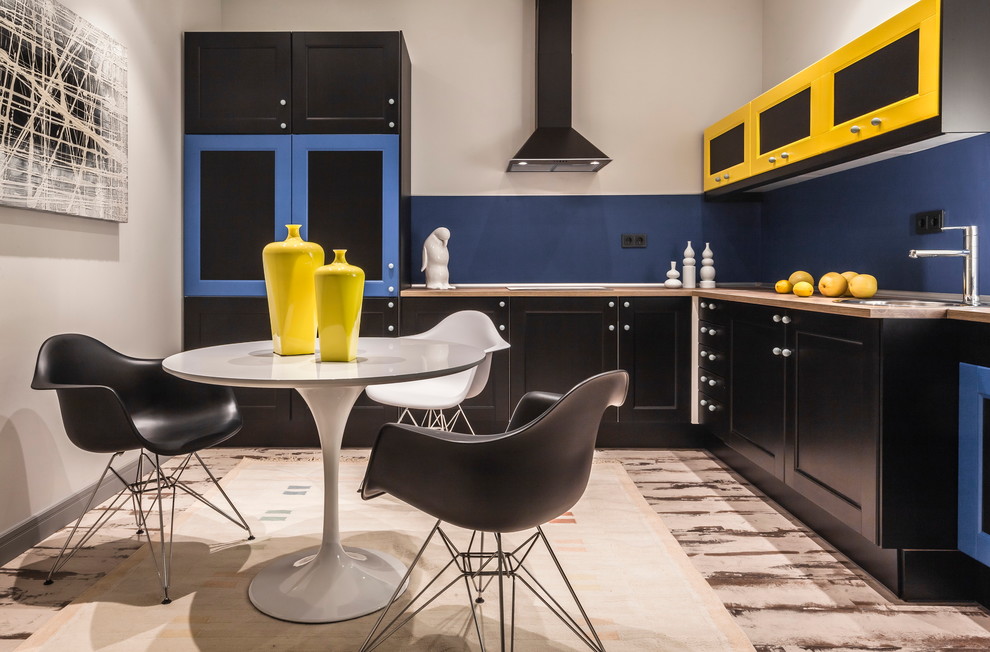Design ideas for a mid-sized scandinavian l-shaped separate kitchen in Other with blue splashback, a drop-in sink, shaker cabinets, no island, dark wood cabinets, wood benchtops, black appliances and laminate floors.