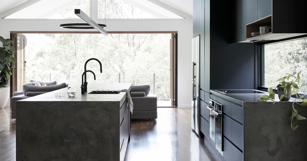 Inspiration for a large modern galley open plan kitchen in Gold Coast - Tweed with an undermount sink, black cabinets, concrete benchtops, window splashback, black appliances, with island and grey benchtop.