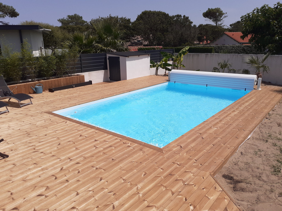 Photo of a large tropical backyard pool in Bordeaux with with privacy feature.