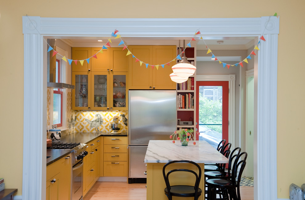 This is an example of a mid-sized eclectic l-shaped separate kitchen in Boston with an undermount sink, shaker cabinets, yellow cabinets, soapstone benchtops and stainless steel appliances.
