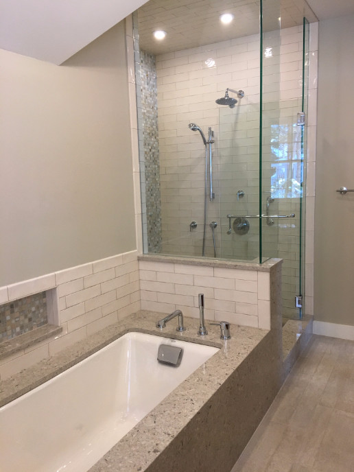 Photo of a mid-sized transitional master bathroom in Portland Maine with an undermount tub, an alcove shower, a two-piece toilet, beige tile, porcelain tile, beige walls, light hardwood floors, beige floor and a hinged shower door.