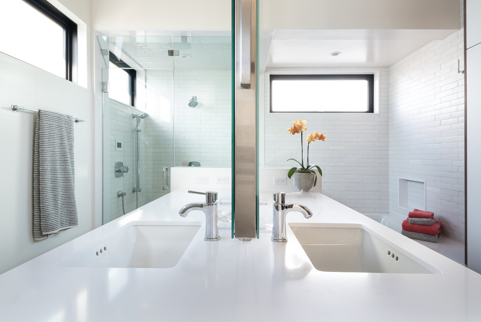 Inspiration for a mid-sized master bathroom in San Diego with flat-panel cabinets, white cabinets, an undermount tub, a curbless shower, a one-piece toilet, white tile, ceramic tile, white walls, cement tiles, an undermount sink, engineered quartz benchtops, a hinged shower door and white benchtops.