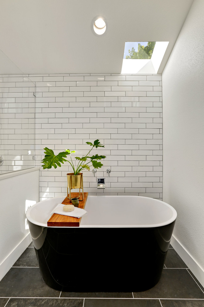 Design ideas for a transitional master bathroom in Seattle with a freestanding tub, white tile, subway tile, white walls and black floor.