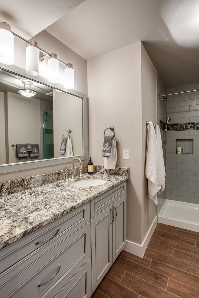 Expansive transitional master bathroom in Seattle with recessed-panel cabinets, grey cabinets, an alcove tub, an alcove shower, a two-piece toilet, brown tile, porcelain tile, beige walls, porcelain floors, an undermount sink and granite benchtops.