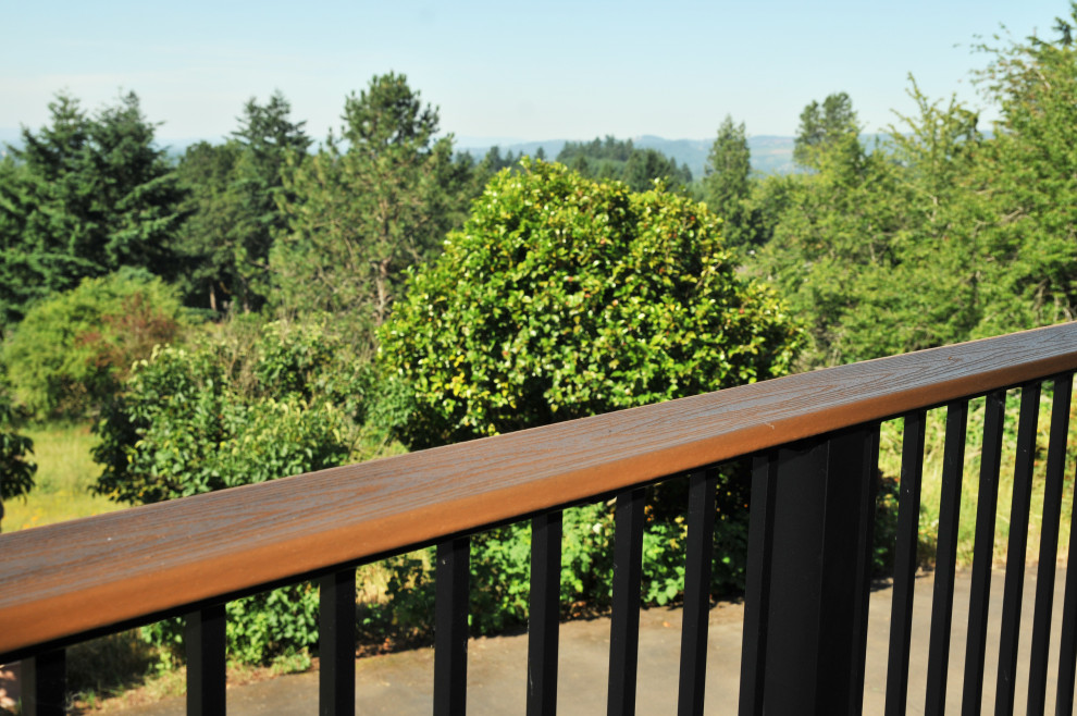 Inspiration for a large contemporary backyard and first floor deck in Portland with an awning and metal railing.
