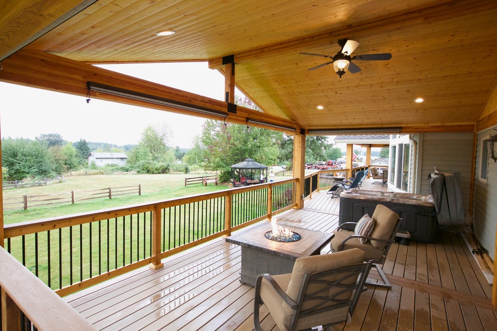 Deck - large rustic backyard deck idea in Seattle with a roof extension and a fire pit