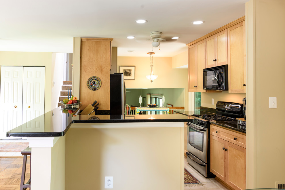Small transitional galley porcelain tile eat-in kitchen photo in DC Metro with an undermount sink, flat-panel cabinets, light wood cabinets, granite countertops, black backsplash, stainless steel appliances and no island