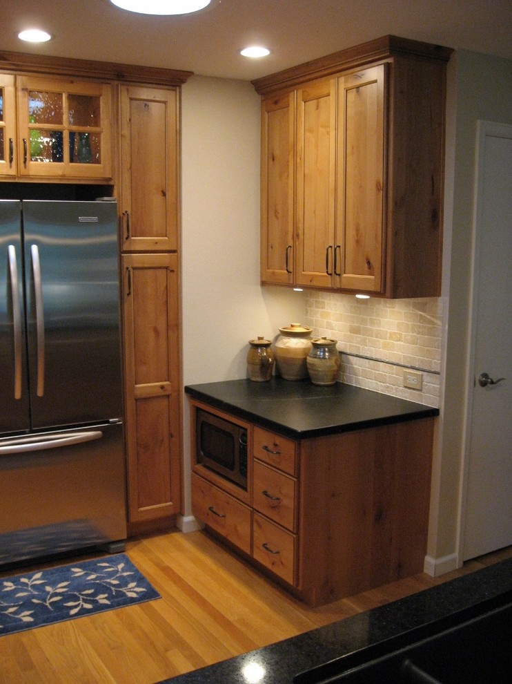Eat-in kitchen - mid-sized rustic l-shaped dark wood floor eat-in kitchen idea in Denver with a double-bowl sink, shaker cabinets, light wood cabinets, quartzite countertops, beige backsplash, stone tile backsplash, stainless steel appliances and a peninsula