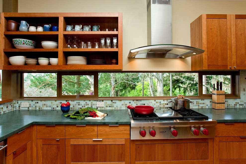 Midcentury u-shaped separate kitchen in Seattle with mosaic tile splashback, stainless steel appliances, medium wood cabinets, recessed-panel cabinets, wood benchtops and multi-coloured splashback.