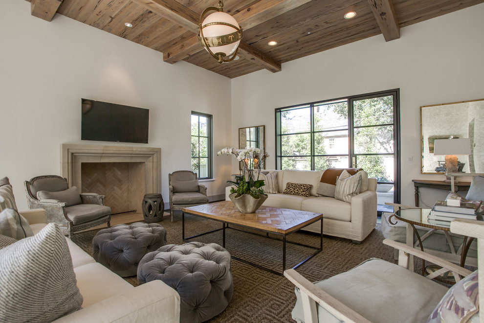 This is an example of a transitional family room in Dallas with beige walls, a standard fireplace, a stone fireplace surround and a wall-mounted tv.
