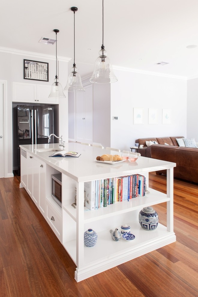 Traditional kitchen in Brisbane with an undermount sink, glass-front cabinets, white cabinets, black appliances, dark hardwood floors and with island.