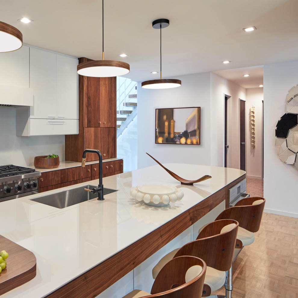 Inspiration for a small midcentury galley kitchen in DC Metro with a submerged sink, flat-panel cabinets, dark wood cabinets, engineered stone countertops, white splashback, engineered quartz splashback, integrated appliances, light hardwood flooring, an island, beige floors and white worktops.