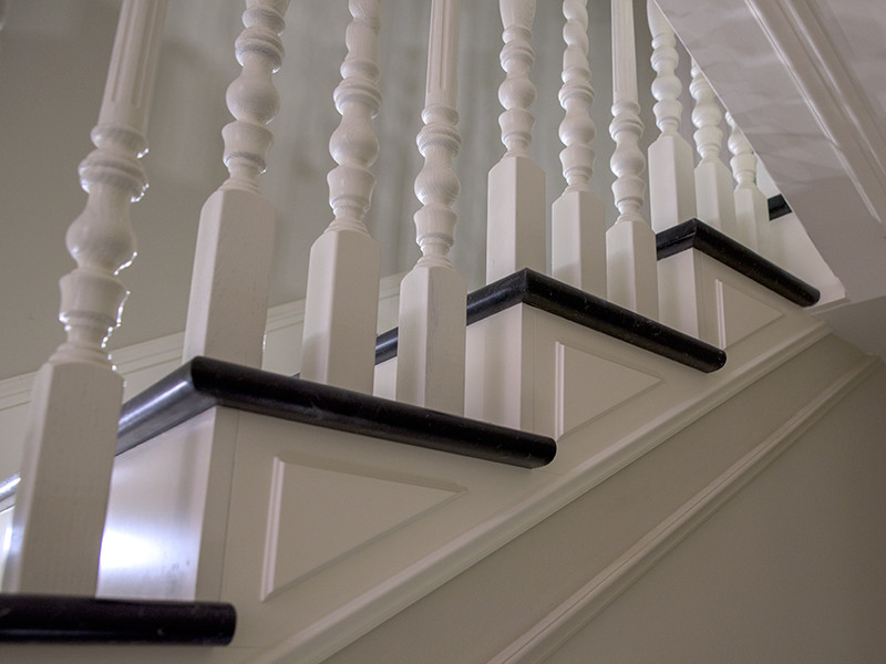 Diseño de escalera recta clásica pequeña con escalones de mármol, contrahuellas de madera y barandilla de madera