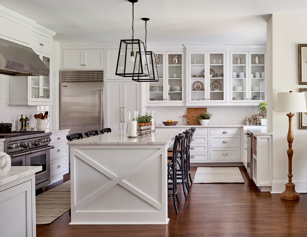 Inspiration for a country l-shaped kitchen in Charlotte with shaker cabinets, white cabinets, white splashback, subway tile splashback, stainless steel appliances, dark hardwood floors, with island and brown floor.