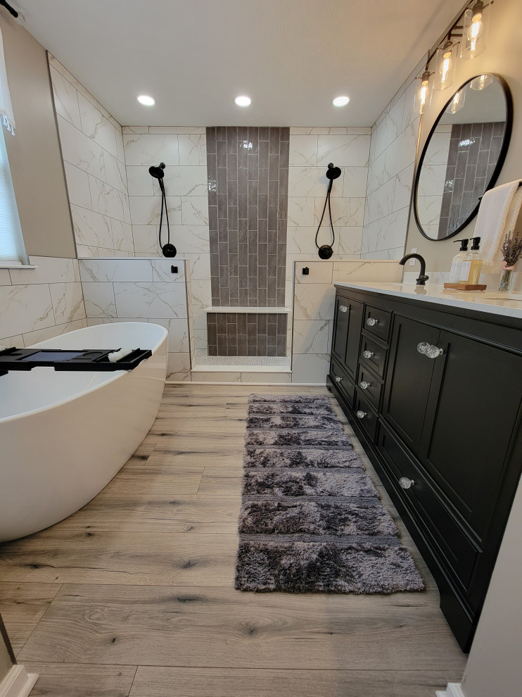 Свежая идея для дизайна: ванная комната среднего размера в стиле неоклассика (современная классика) с черными фасадами, отдельно стоящей ванной, двойным душем, черно-белой плиткой, керамической плиткой, бежевыми стенами, полом из ламината, монолитной раковиной, столешницей из искусственного кварца, бежевым полом, открытым душем, белой столешницей, тумбой под две раковины и напольной тумбой - отличное фото интерьера